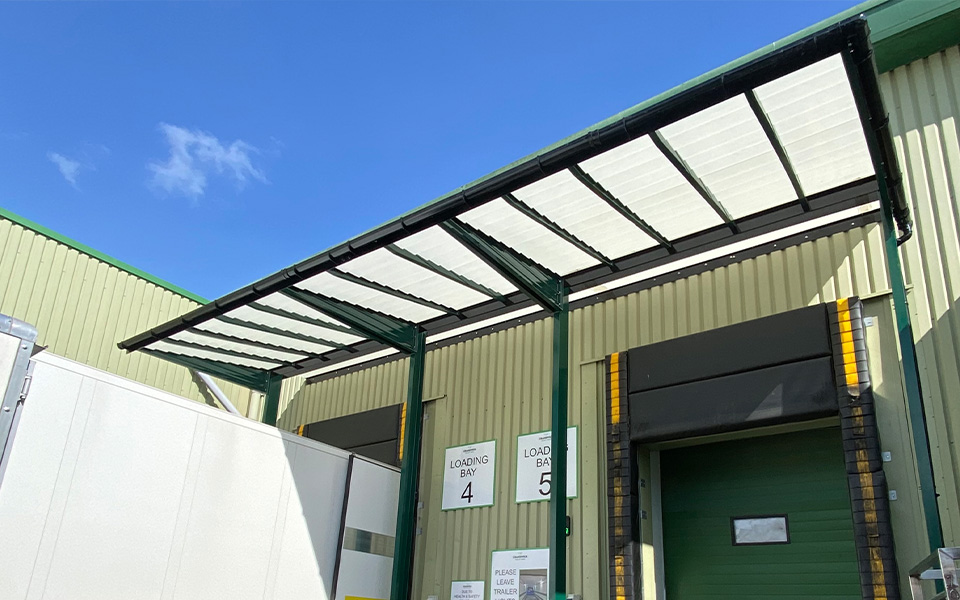 A green loading bay canopy covering two loading bays