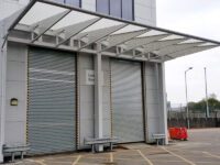 Large silver loading bay shelter covering two roller shuttered bays