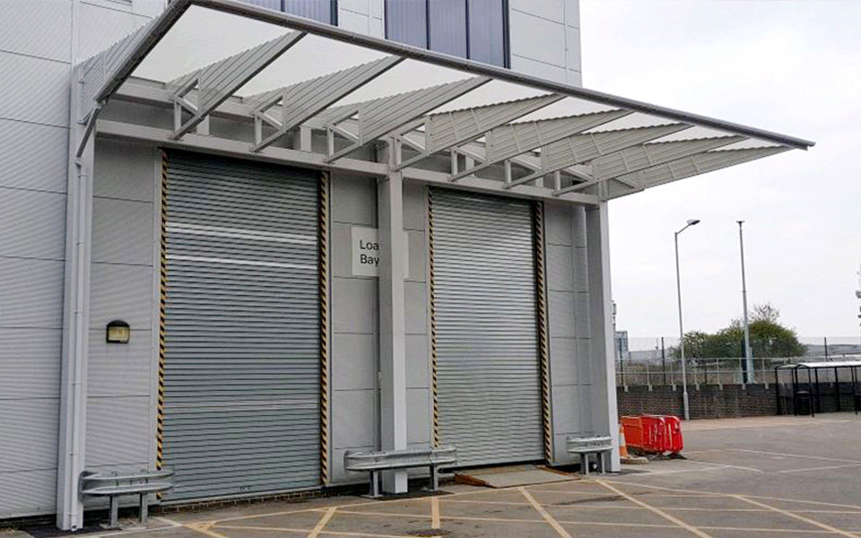Large silver loading bay shelter covering two roller shuttered bays