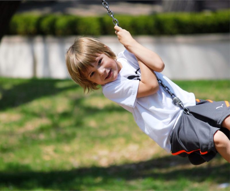 child playing on swing