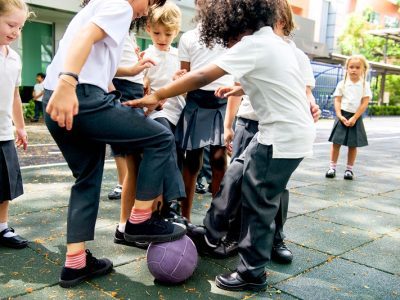 school children playing football outside