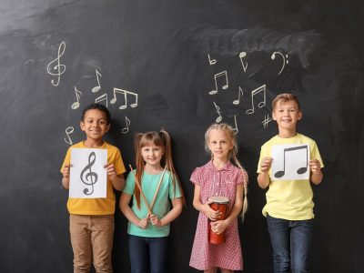 Children near chalkboard covered in music notes