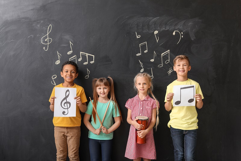 Children near chalkboard covered in music notes