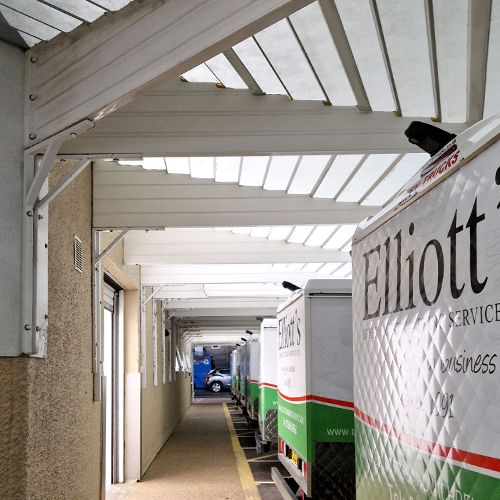 A loading bay canopy covering several vans for Elliott's upper crust catering services.