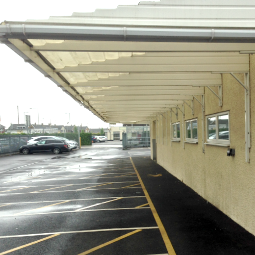 A white canopy attached to a building at the Elliott's Upper Crust offices. The canopy covers the walkway around the building